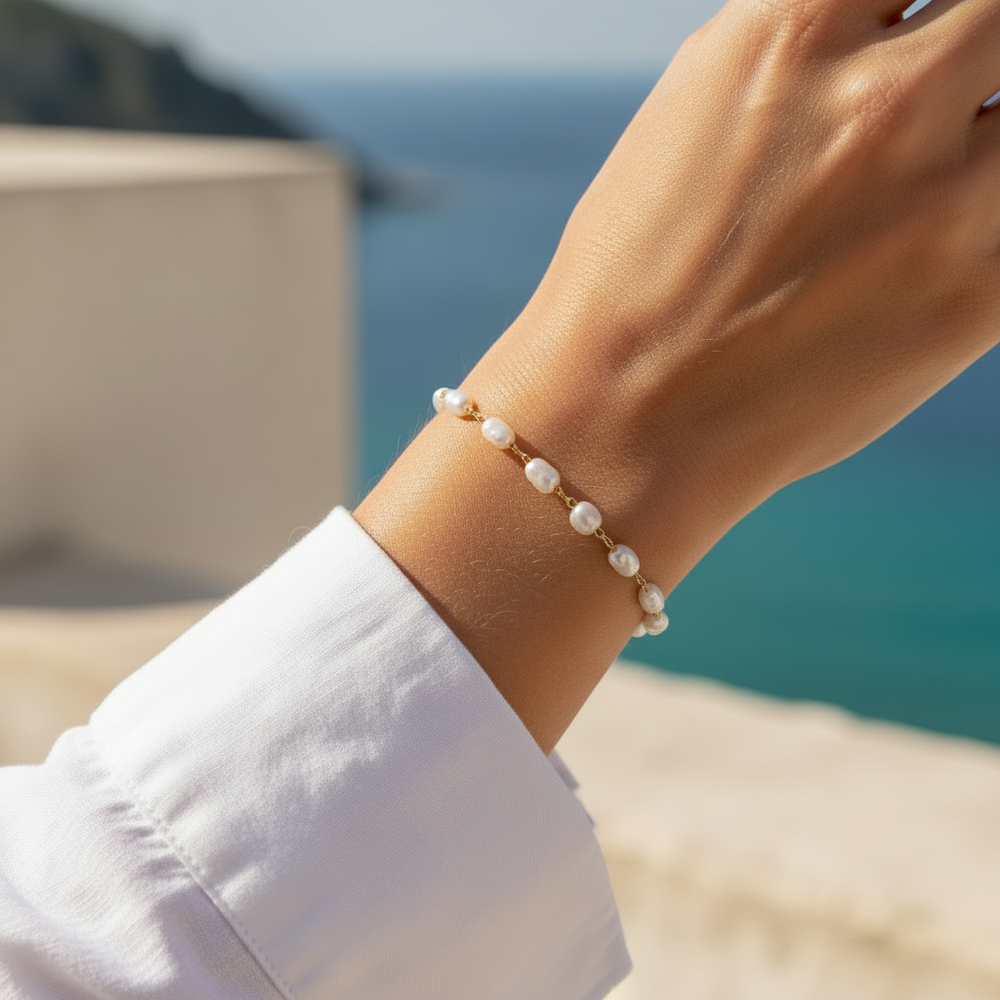 Close-up of the Bionda 18K gold-filled simulated baroque pearl bracelet worn on a model’s wrist on the Amalfi Coast