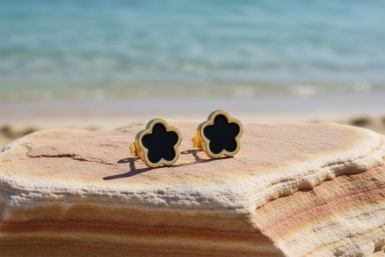 Fiorella 18K Gold Plated Black Flower Stud Earrings - Earrings on a Stone with Beach in the Background | Amalfi Lane