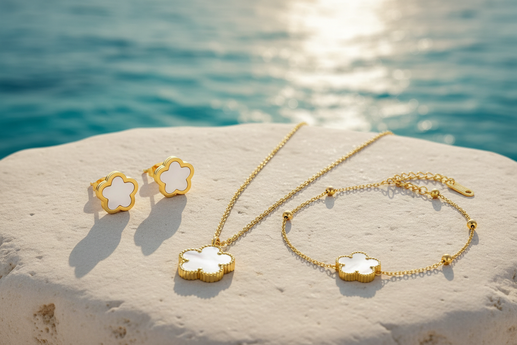 Fiorella 18K Gold Plated White Flower Stud Earrings - Fiorella White Pendant, Earrings and Bracelet Set on White Rock with Beach in the Background | Amalfi Lane