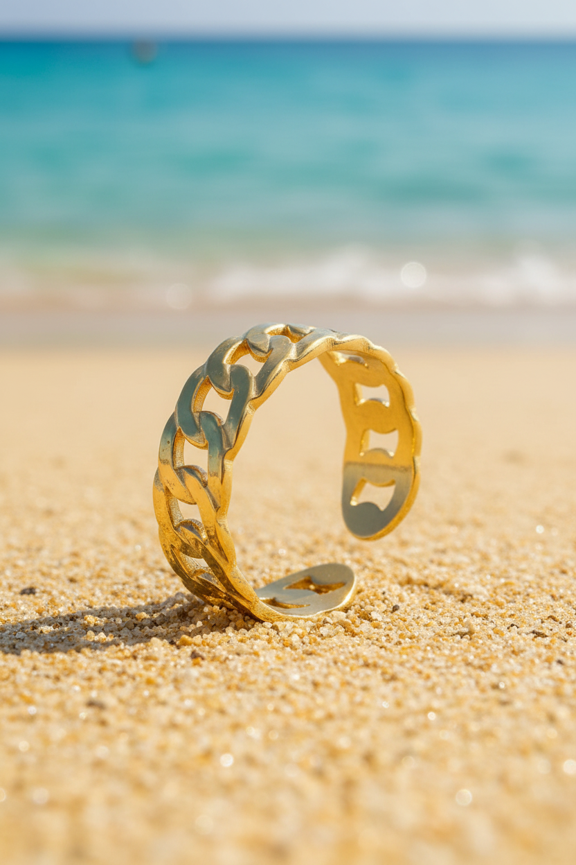 Elena 18K Gold Plated Curb Chain Adjustable Ring Placed Naturally in Warm Sand with Turquoise Mediterranean Sea Amalfi Coast | Sun-Kissed Collection | Amalfi Lane Australia