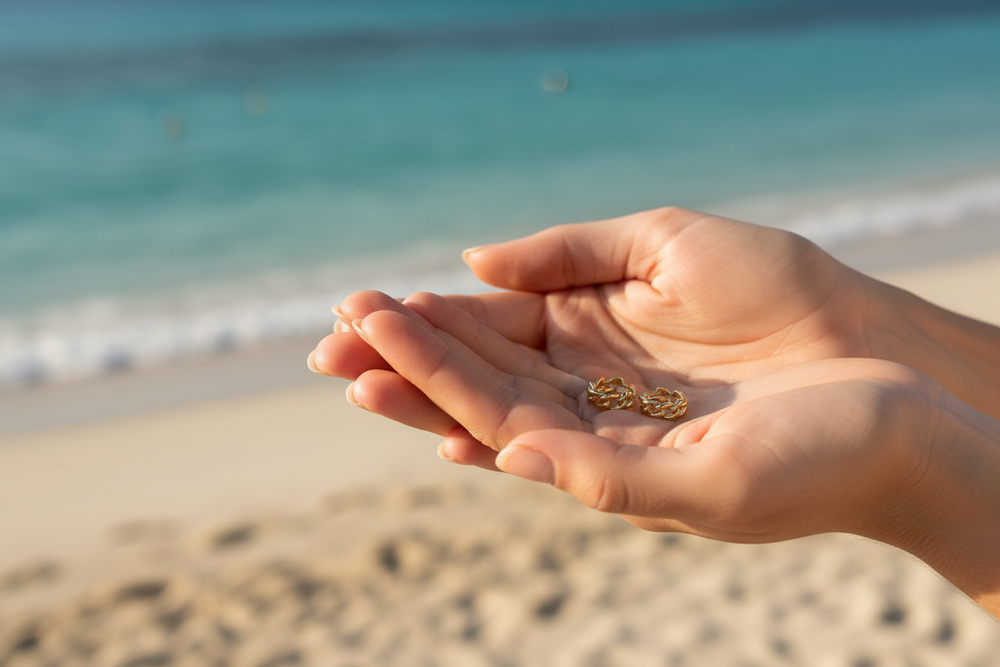 Lola 18K Gold-Filled Mini Cuban Link Chain C-Hoop Earrings held in hands at the beach